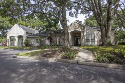 a house with a driveway and trees in front of it