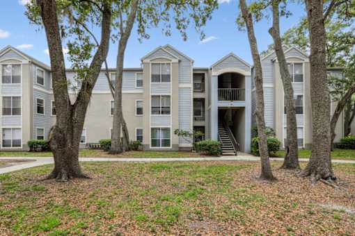 A large apartment complex with a grassy area in front.