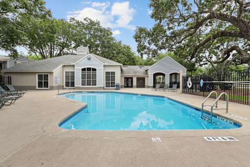 A swimming pool in front of a house.