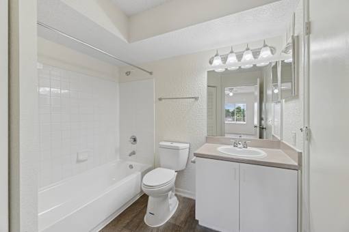 A white bathroom with a toilet, sink, and bathtub.