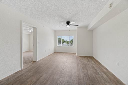 A room with wooden flooring and a ceiling fan.