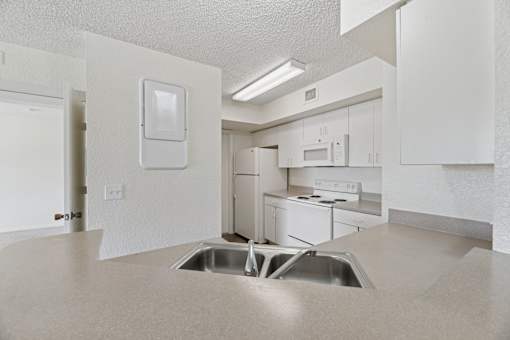 A kitchen with white appliances and cabinets.