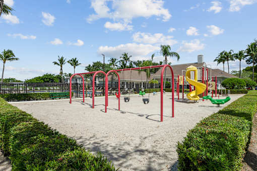 A playground with a red swing set and a yellow slide.