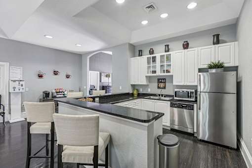 A modern kitchen with a bar area and stainless steel appliances.