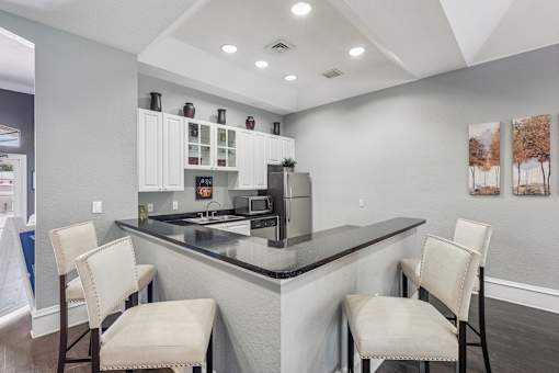 A kitchen with a black counter top and white cabinets.