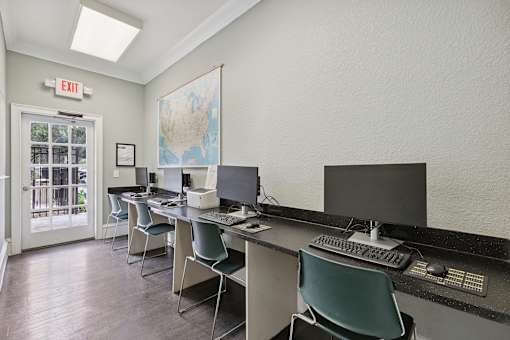 A room with a map of the United States on the wall and a red exit sign above the door.