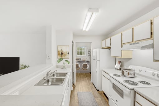 a kitchen with white cabinetry and a stainless steel sink
