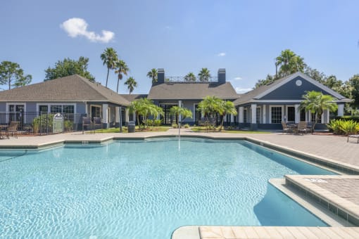 resort style pool with palm trees and lounge seating