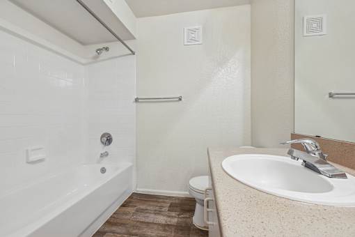A white bathroom with a sink, toilet, and bathtub.