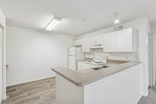 A kitchen with white cabinets and a counter.