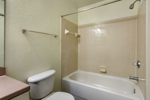 a bathroom with a white bathtub and a white toilet