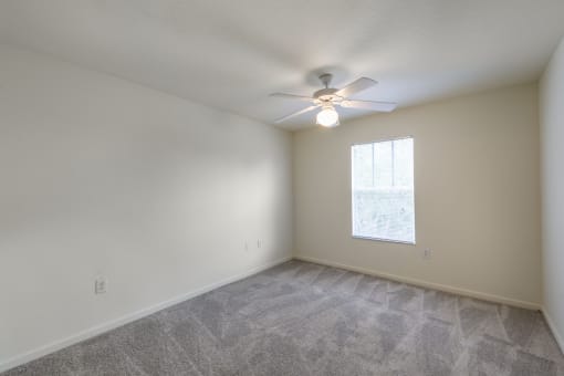 a bedroom with a ceiling fan and a window