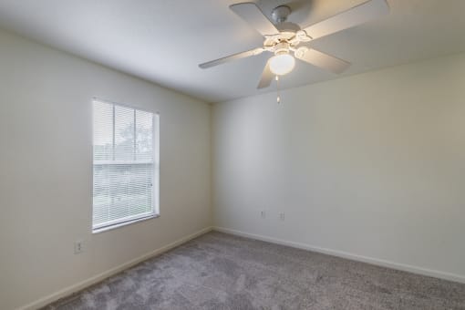 a bedroom with a ceiling fan and a window