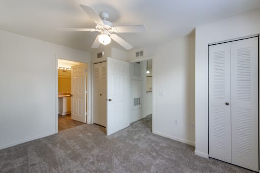 a bedroom with a ceiling fan and closet
