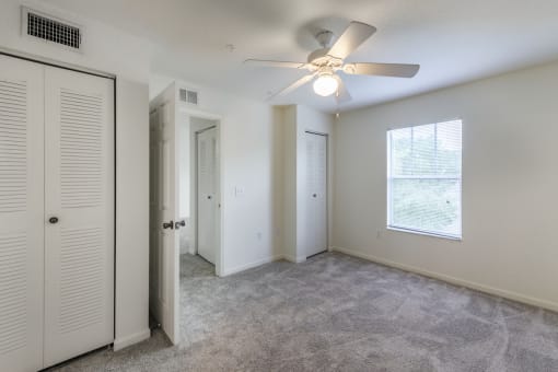 a bedroom with a ceiling fan and closet