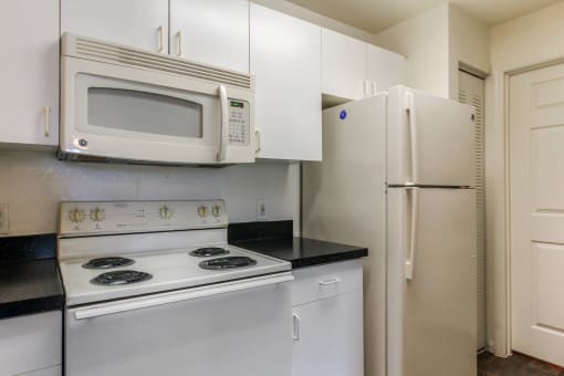 a kitchen with white appliances and white cabinets