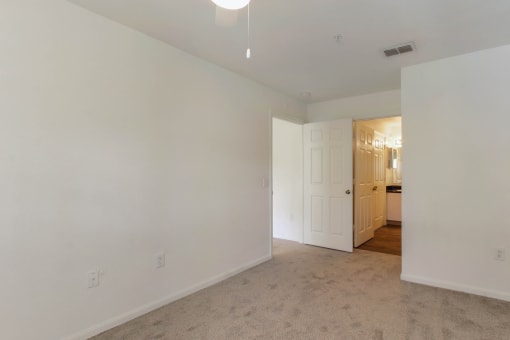 a bedroom with white walls and carpet