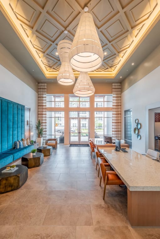a lobby with a long table and chairs and large windows