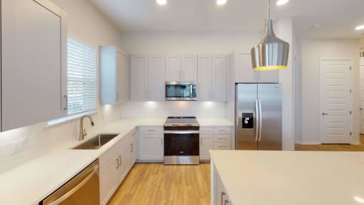 a kitchen with white cabinets and a stainless steel refrigerator