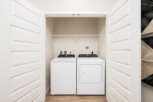 a white washer and dryer in a laundry room with white doors
