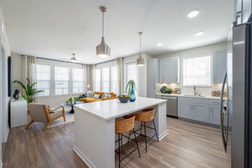 an open kitchen and living room with a white counter top