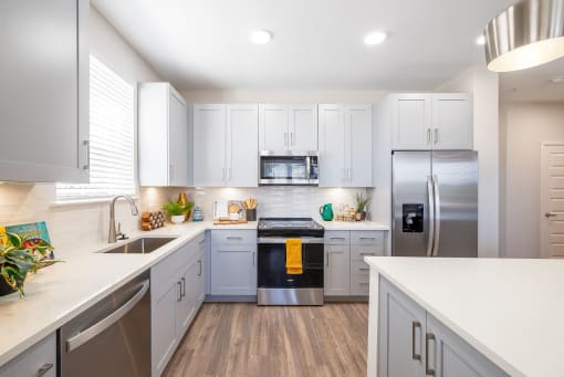 a renovated kitchen with white cabinets and stainless steel appliances