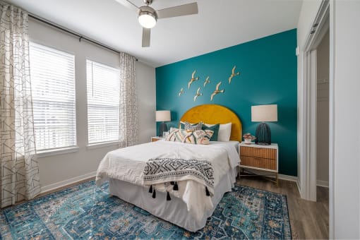 a bedroom with a blue wall and a white bed