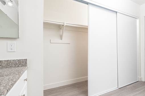 A white closet with a white door and a white shelf.