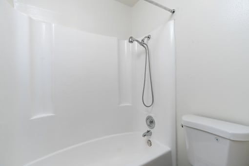 A white bathroom with a tub and shower.