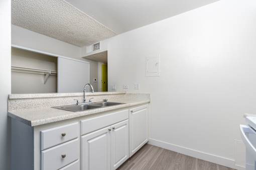 A kitchen with white cabinets and a sink.