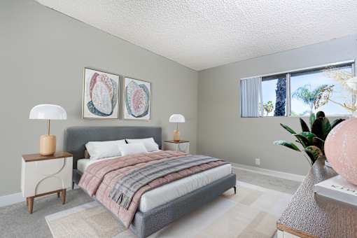 A bedroom with a bed, nightstand, and two lamps.