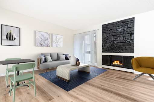 A living room with a fireplace and a grey couch.