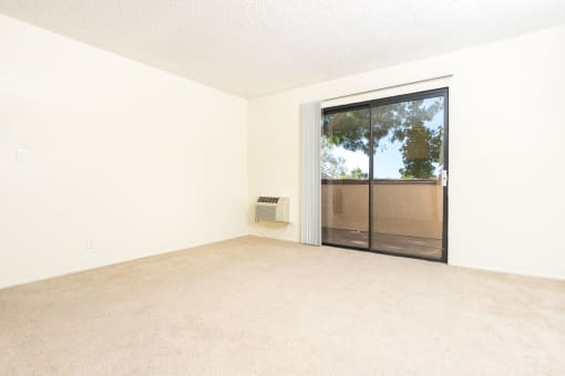 an empty living room with a sliding glass door