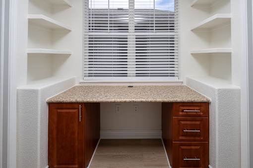 A small home office with a desk and drawers.