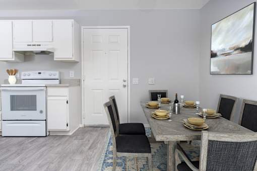 A modern kitchen with a dining table set for two.