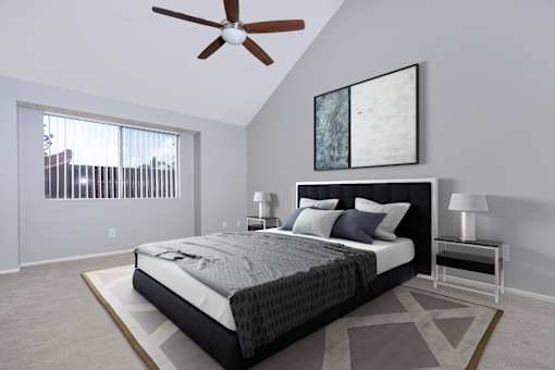 A bedroom with a large bed and a ceiling fan.