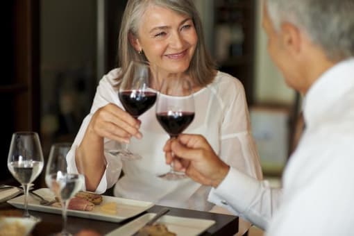 a couple of people sitting at a table drinking wine