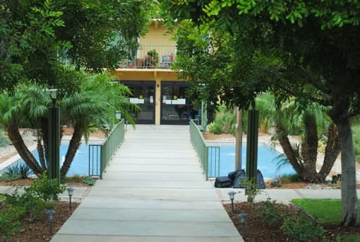 a concrete walkway leading up to a swimming pool