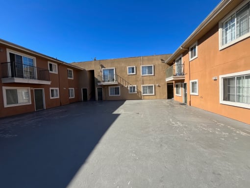 the courtyard of a building with an empty parking lot