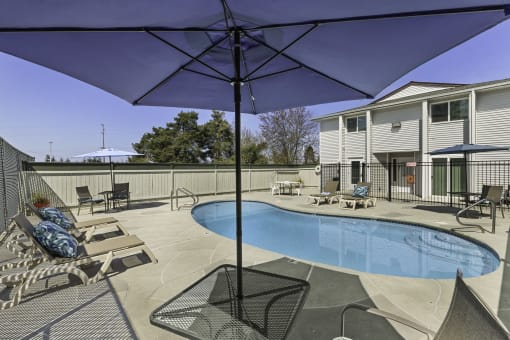 Resort Style Pool with Lounge Chairs and Shaded Bistro Set at Campo Basso Apartment Homes, Lynnwood, 98087