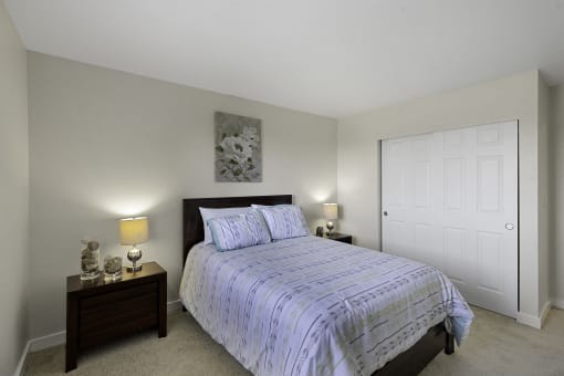 a bedroom with a bed and two night stands at Campo Basso Apartment Homes, Washington, 98087