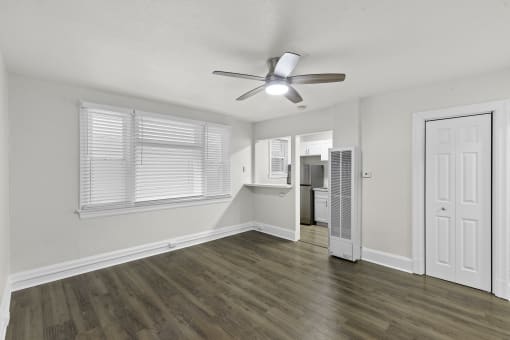 Spacious Living Room with Hardwood Flooring, Wide Windows with White Blinds, and an Overhead Light/Ceiling Fan at Carolina Court Apartment Homes, Washington, 98109