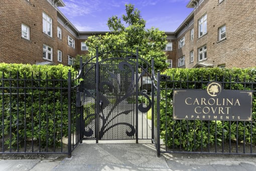 Iron Gate Covered in Greenery with Carolina Court Apartment Homes Property Sign at Carolina Court Apartment Homes, WA 98109