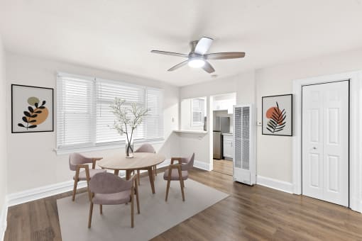 a living room with a table and chairs and a ceiling fan