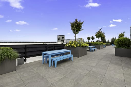 Rooftop Resident Lounge with a table and benches at Arabella Apartment Homes, Shoreline, WA