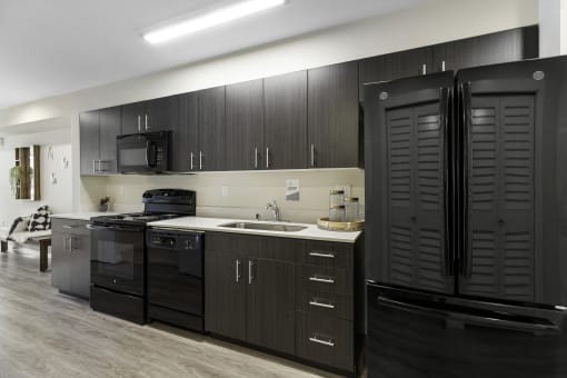 a kitchen with black cabinets and a black refrigerator at Arabella Apartment Homes, Shoreline, 98155