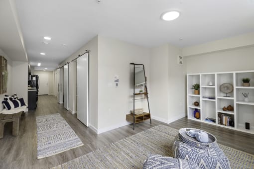 Apartment Living Area with Plank Flooring and cozy rugs, white bookshelf, and recessed lighting at Arabella Apartment Homes, Washington