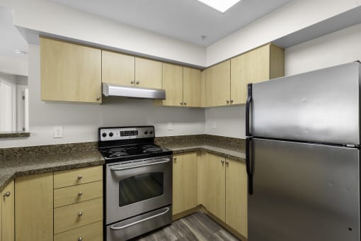Cozy Kitchen Space with Plank Flooring, Stainless Steel Appliances, and Wood-look Cabinetry at Arabella Apartment Homes, Washington
