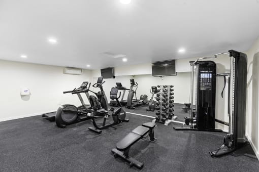 a gym with cardio equipment and a flat screen tv  at Casa Blanca Apartment Homes, Washington, 98204
