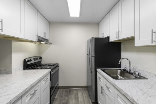 Spacious kitchen with Plank Flooring, Overhead Lighting, and White Cabinetry at Casa Blanca Apartment Homes, Everett